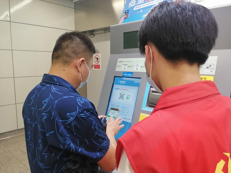 图3：学生第二党支部党员引导地铁站的行人购票.jpg